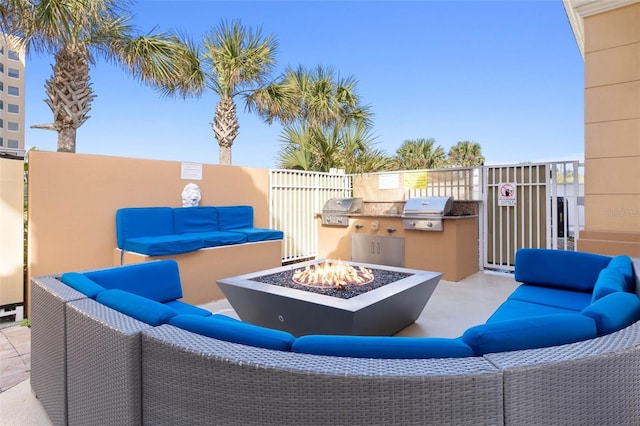 view of patio / terrace featuring exterior kitchen, grilling area, and an outdoor living space with a fire pit