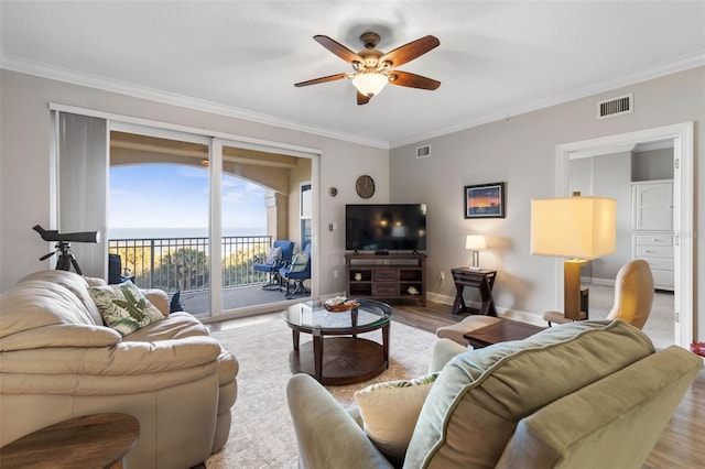 living area featuring ornamental molding, wood finished floors, and visible vents