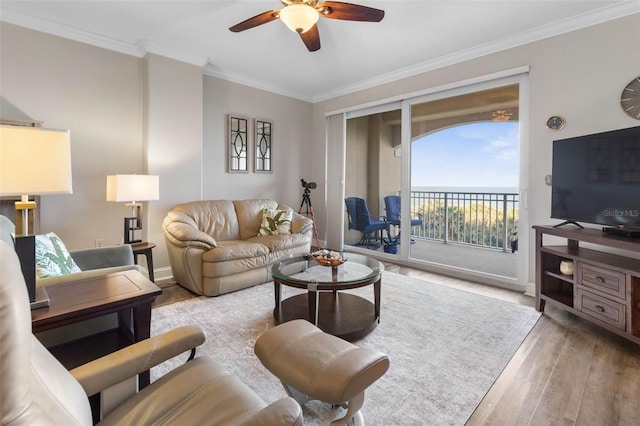 living room featuring ornamental molding, a ceiling fan, and wood finished floors