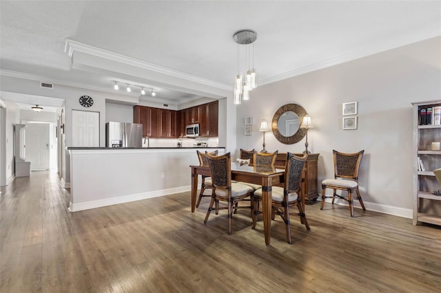 dining space with baseboards, crown molding, a chandelier, and wood finished floors