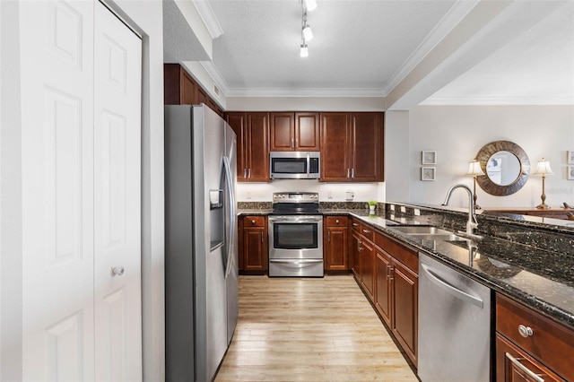 kitchen featuring appliances with stainless steel finishes, light wood-style floors, crown molding, and a sink