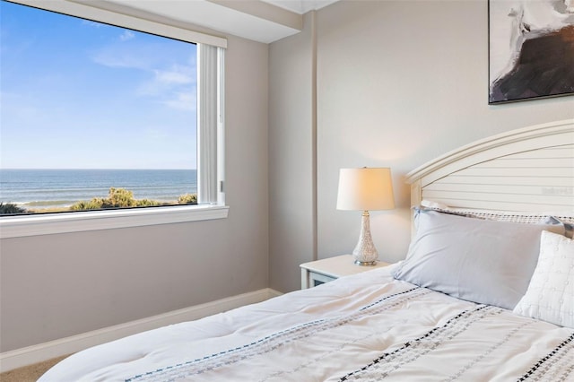 bedroom with a water view and baseboards