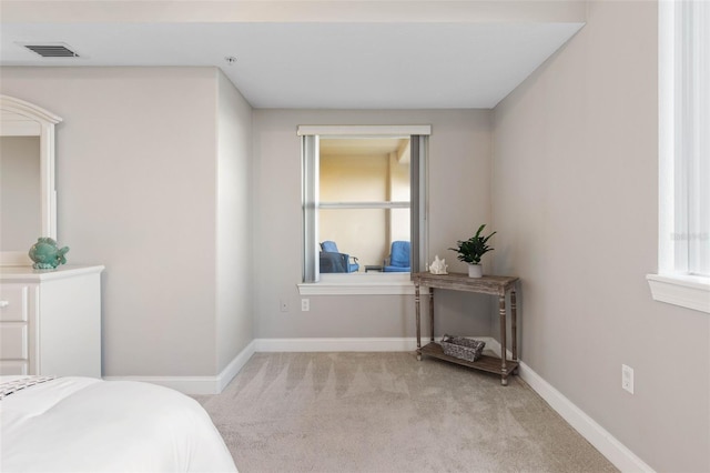 bedroom featuring visible vents, baseboards, and light colored carpet