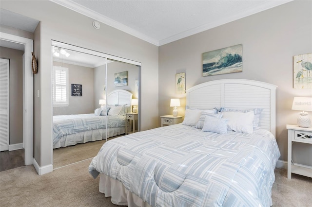 carpeted bedroom with ornamental molding, a closet, and baseboards