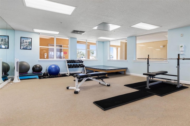 workout room with a textured ceiling, carpet flooring, visible vents, and baseboards