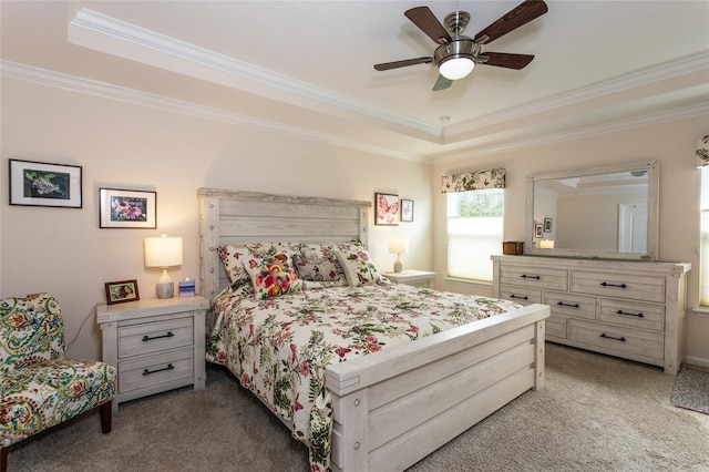 carpeted bedroom with ceiling fan, a raised ceiling, and crown molding