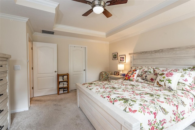 bedroom featuring light colored carpet, a ceiling fan, visible vents, a tray ceiling, and crown molding