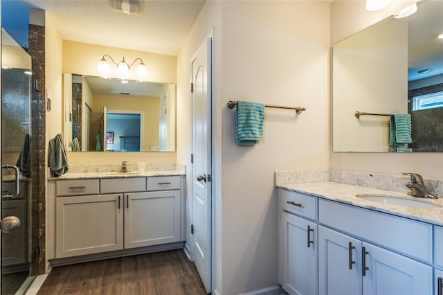 full bathroom with a shower stall, visible vents, a sink, and wood finished floors