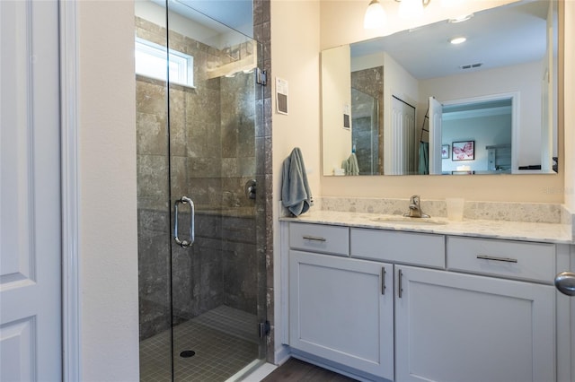 full bathroom featuring visible vents, a shower stall, and vanity