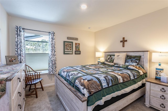 bedroom featuring baseboards and light colored carpet