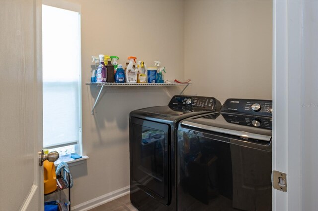 washroom with laundry area, washer and clothes dryer, and baseboards