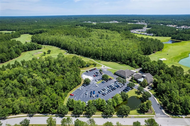 drone / aerial view featuring a forest view, a water view, and golf course view