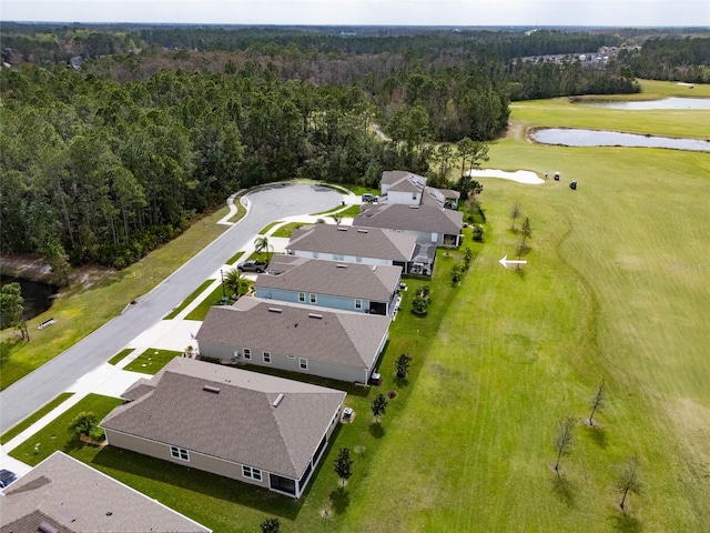 drone / aerial view featuring golf course view, a water view, a residential view, and a view of trees