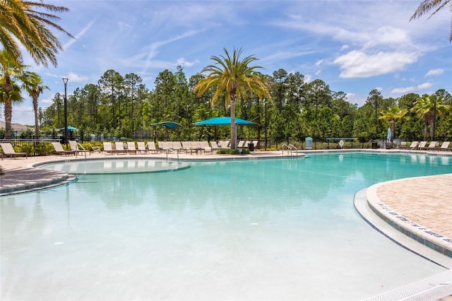 pool featuring fence and a patio