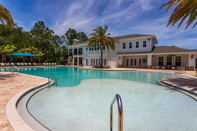 community pool with french doors and a patio area