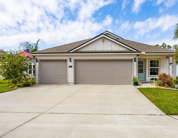 single story home featuring driveway, an attached garage, and board and batten siding