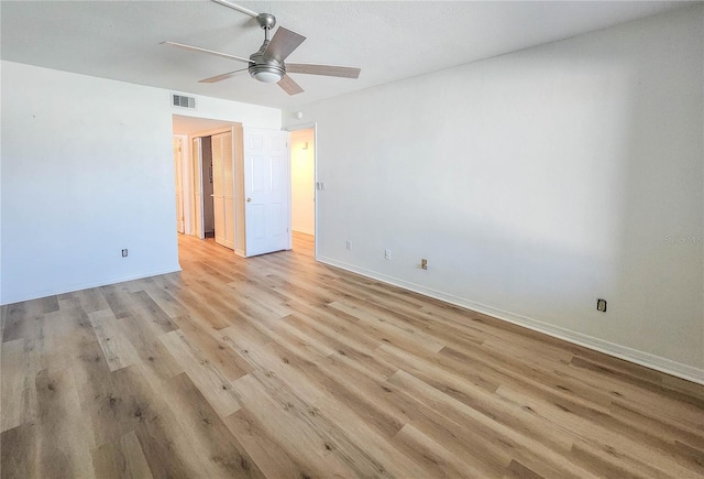 unfurnished room featuring light wood-type flooring, visible vents, baseboards, and a ceiling fan