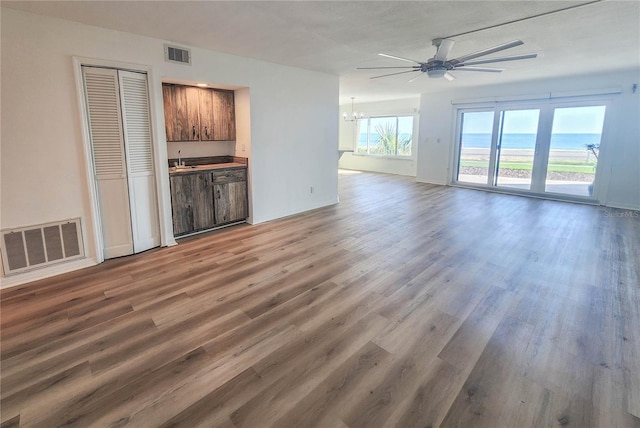 unfurnished living room with visible vents and wood finished floors