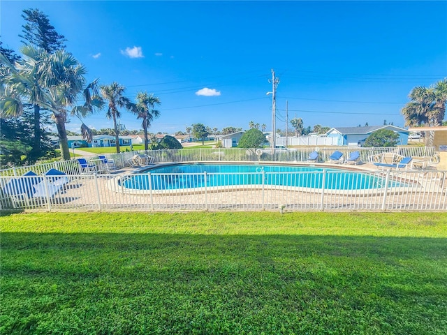 pool featuring a yard, a patio area, and fence