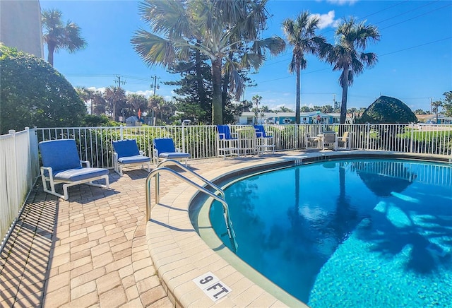 community pool with fence and a patio