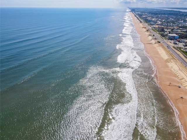 drone / aerial view featuring a beach view and a water view