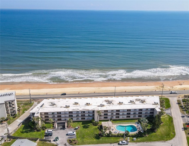 drone / aerial view featuring a beach view and a water view