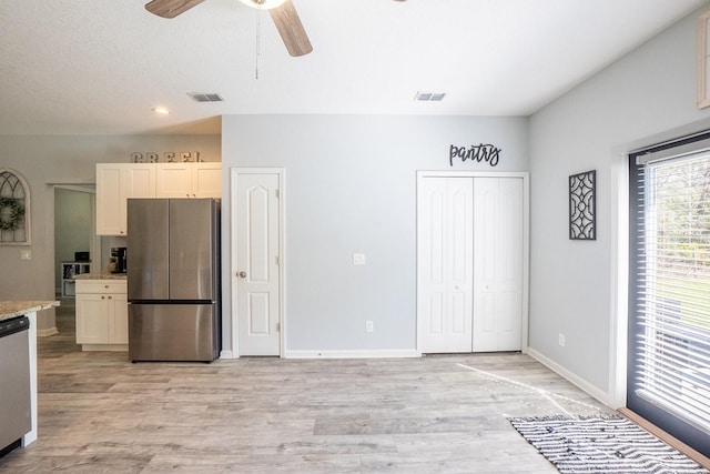 kitchen with light wood finished floors, stainless steel appliances, visible vents, ceiling fan, and baseboards