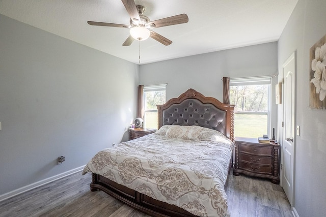 bedroom featuring ceiling fan, baseboards, and wood finished floors