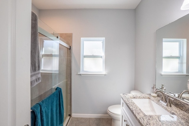 full bath featuring toilet, a stall shower, vanity, tile patterned flooring, and baseboards