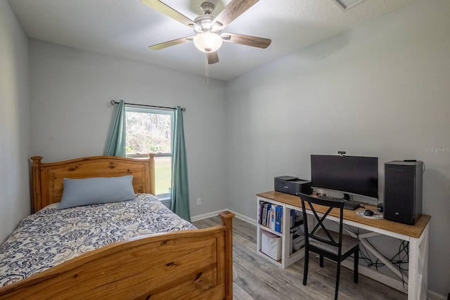 bedroom with light wood finished floors, baseboards, and a ceiling fan