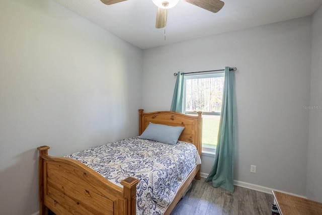 bedroom with ceiling fan, wood finished floors, and baseboards