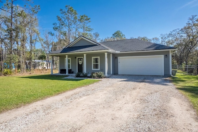 view of front facade with a garage, driveway, a front lawn, and fence