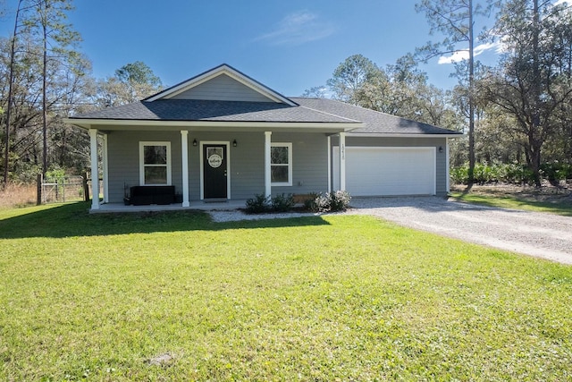 view of front of house featuring covered porch, driveway, a front lawn, and an attached garage