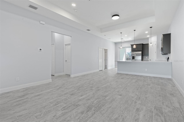 unfurnished living room featuring light wood-style flooring, visible vents, baseboards, and recessed lighting