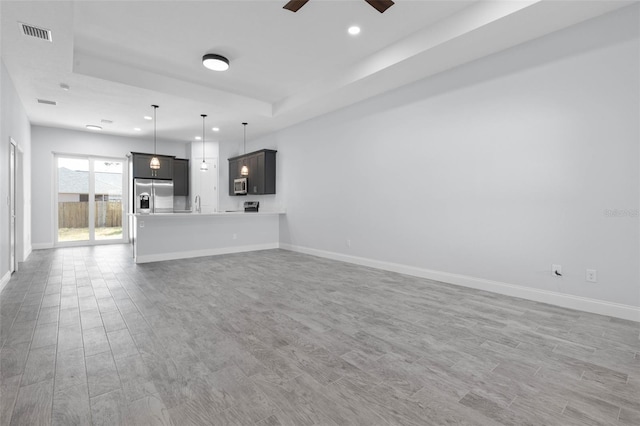 unfurnished living room with light wood finished floors, recessed lighting, visible vents, a ceiling fan, and baseboards