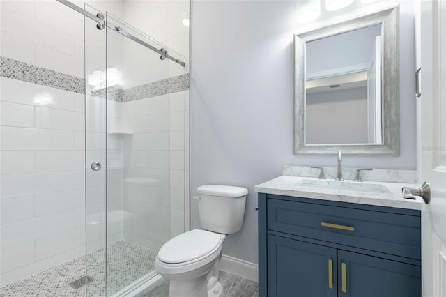 bathroom featuring baseboards, a shower stall, toilet, and vanity