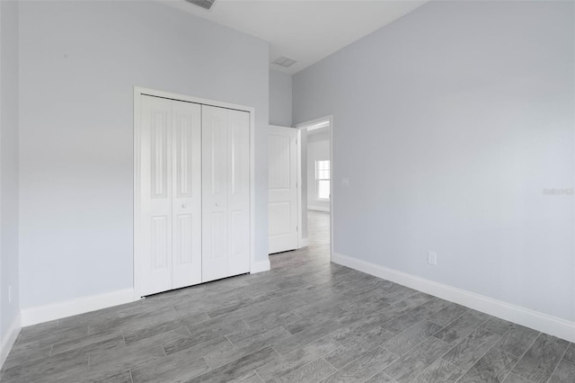 unfurnished bedroom featuring baseboards, a closet, and wood finished floors