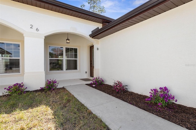 doorway to property featuring stucco siding