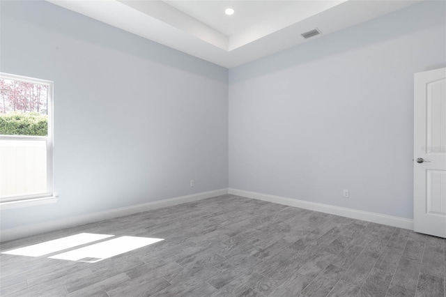 spare room featuring recessed lighting, wood finished floors, visible vents, and baseboards