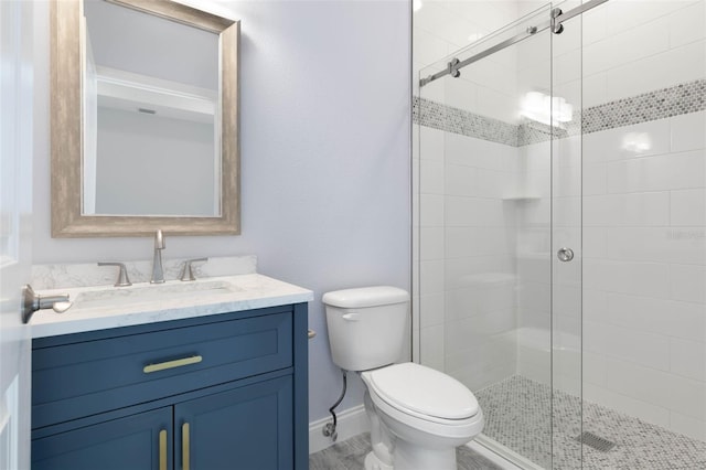 full bath featuring toilet, a shower stall, baseboards, and vanity