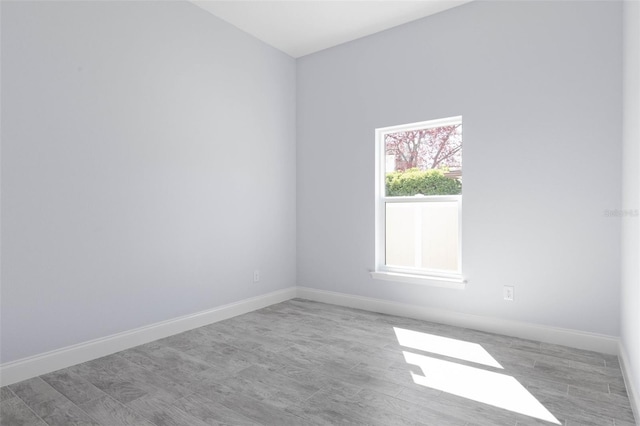 empty room with baseboards and wood finished floors