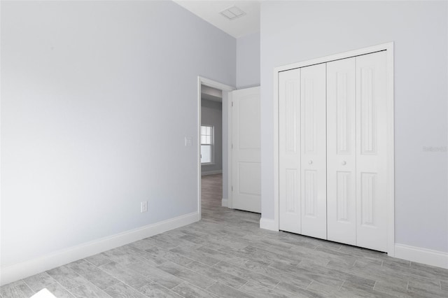 unfurnished bedroom with light wood finished floors, visible vents, and baseboards