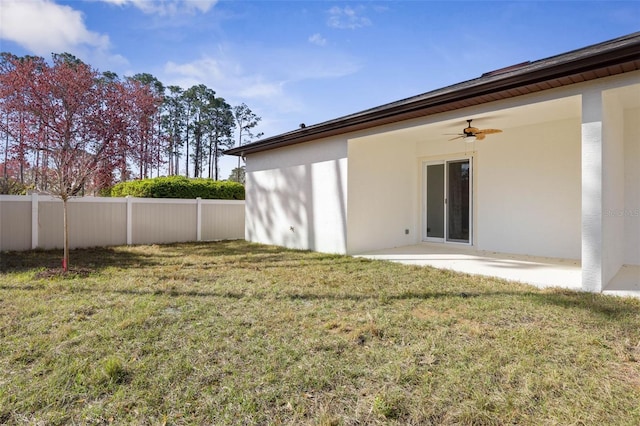 back of house with a yard, a patio area, fence, and stucco siding