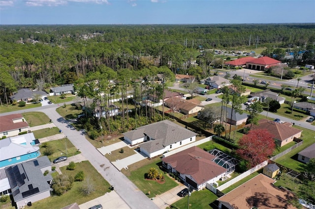 drone / aerial view featuring a residential view and a wooded view