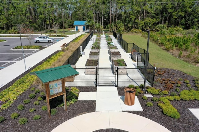 view of community featuring a gate, fence, and a lawn