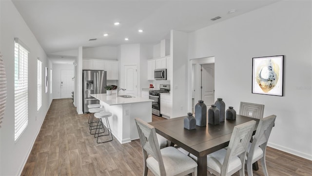 dining room with light wood-style floors, recessed lighting, visible vents, and baseboards