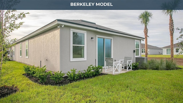 rear view of property with a lawn, cooling unit, and stucco siding