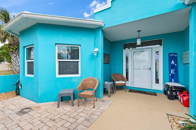 doorway to property with a patio and stucco siding