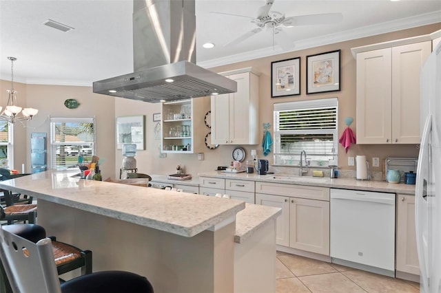 kitchen with a breakfast bar area, ornamental molding, island exhaust hood, white appliances, and a sink