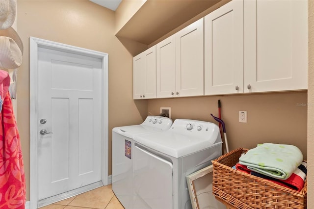 laundry room with cabinet space, light tile patterned flooring, and washing machine and dryer